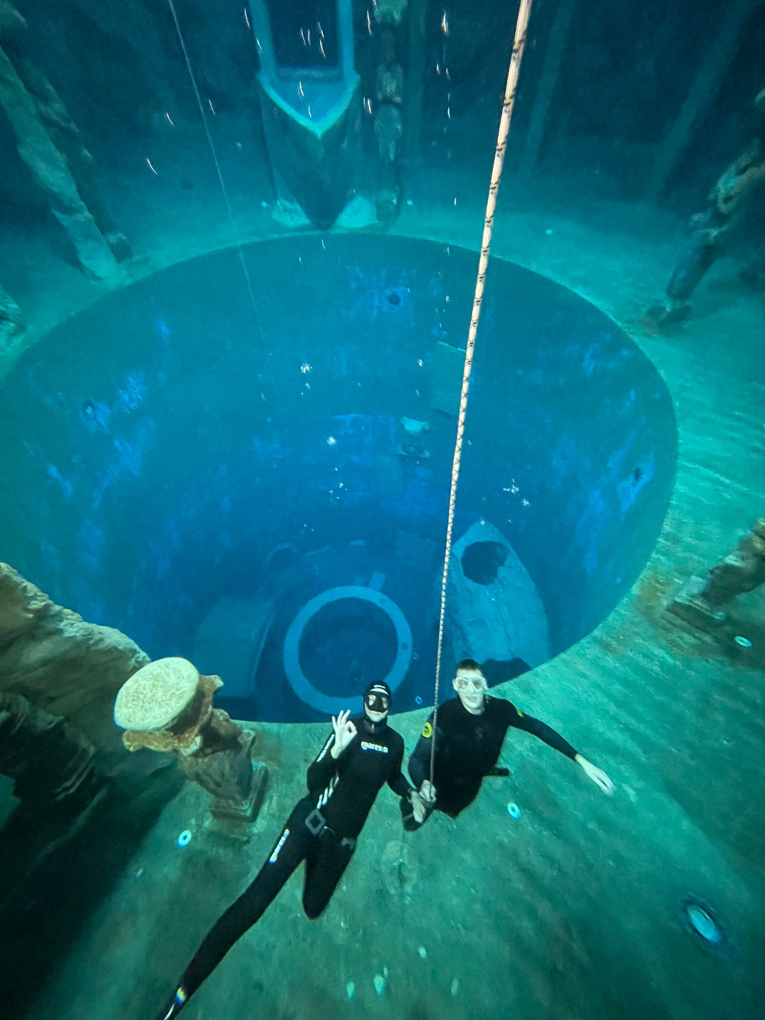 Bild zweier fröhlicher Apnoetaucher im Tauchturm unter Wasser.