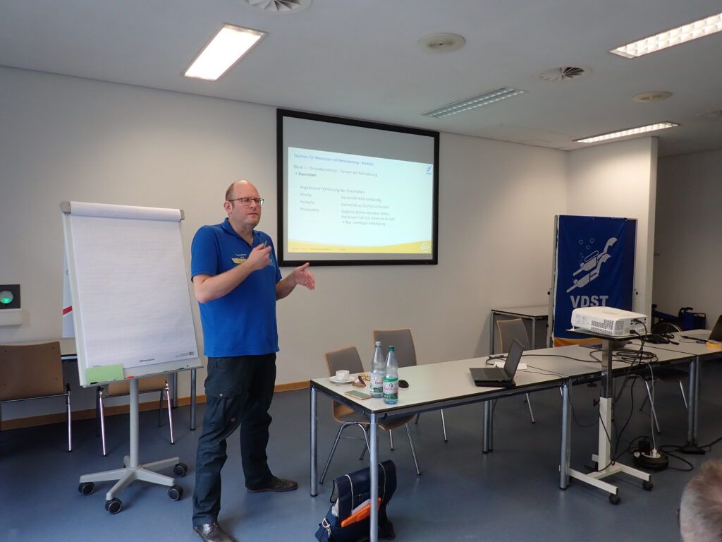 Person die auf einer Vorbildung einen Vortrag hält.